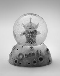 A Toy Story snow globe that Steve kept in his office, with a three-eyed alien and a base that reads: Ooooh!