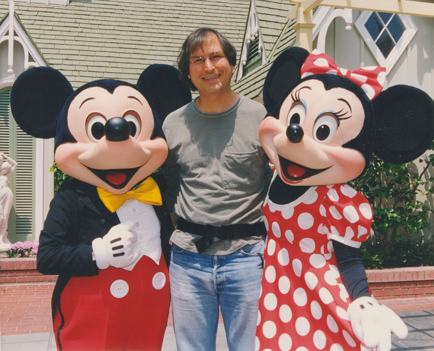 Steve, smiling, poses with Mickey and Minnie Mouse at Disneyland.