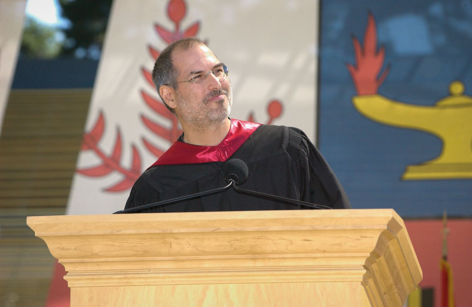 Steve smiles at the lectern in graduation robes while giving the 2005 commencement speech at Stanford University.