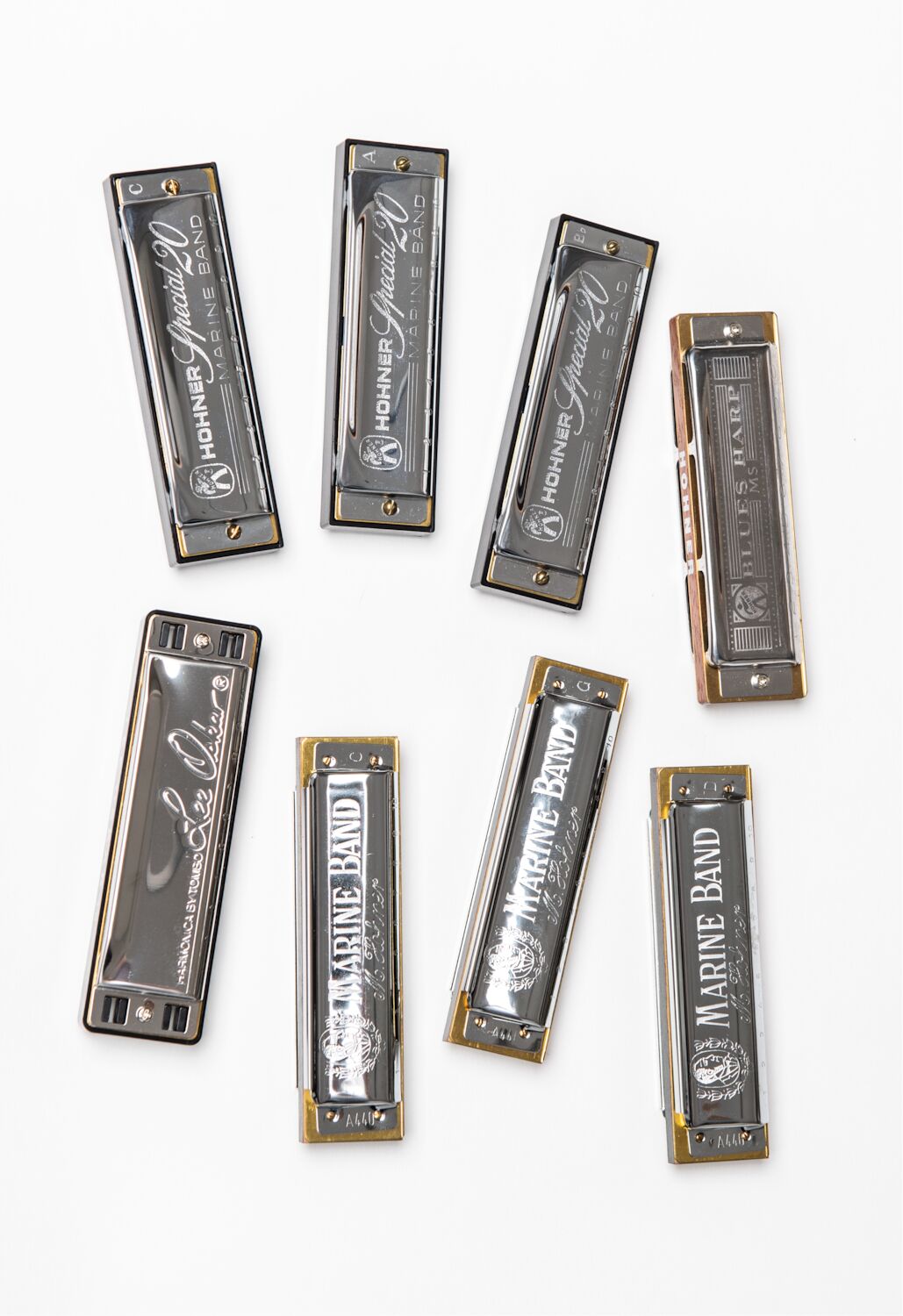 Eight bright metal harmonicas, from brands such as Marine Band and Hohner, that Steve collected.