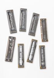 Eight bright metal harmonicas, from brands such as Marine Band and Hohner, that Steve collected.