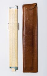 Steve’s vintage slide rule sits next to its brown leather case.