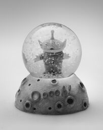 A Toy Story snow globe that Steve kept in his office, with a three-eyed alien and a base that reads: Ooooh!